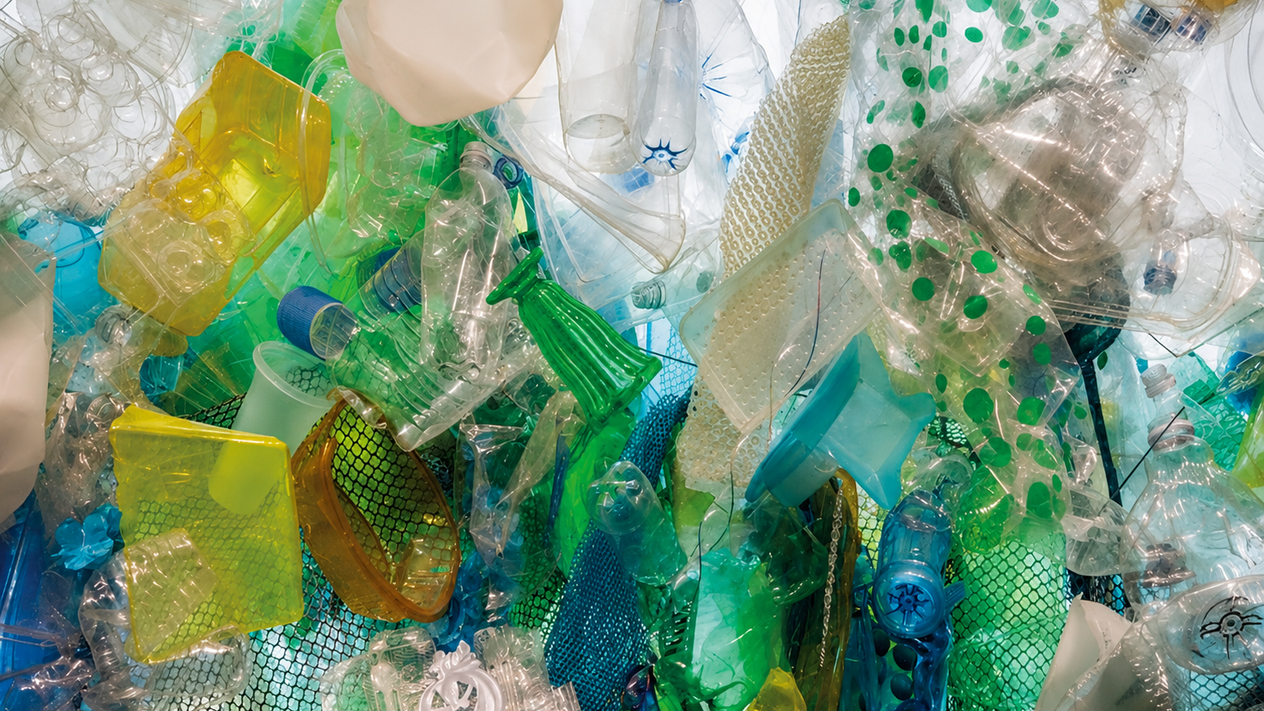 A close-up of a recycled plastic sculpture by artist Katharine Harvey includes various colored pieces of single-use plastics