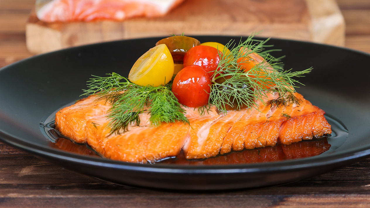 Seared arctic char with citrus vinaigrette and garnished with tomatoes and dill